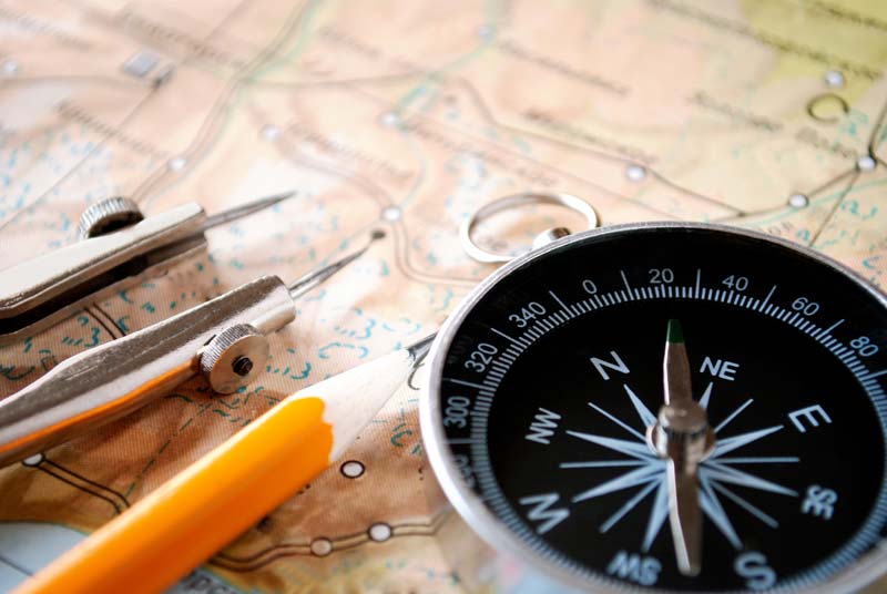 Image of a compass and pencils on top of an old map.